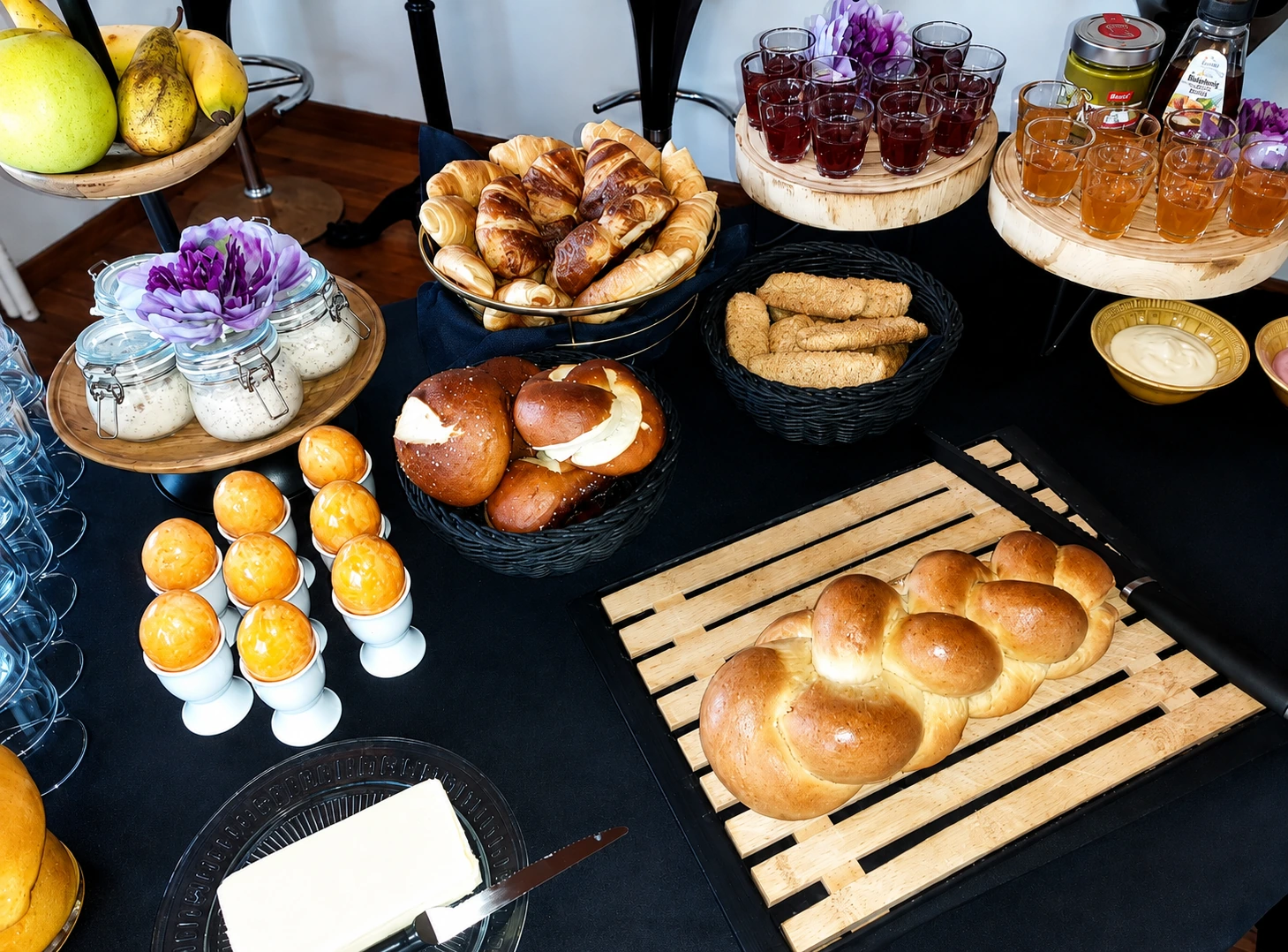 Frühstücksbuffet mit Zopf, Brötchen und kleinen Gläsern